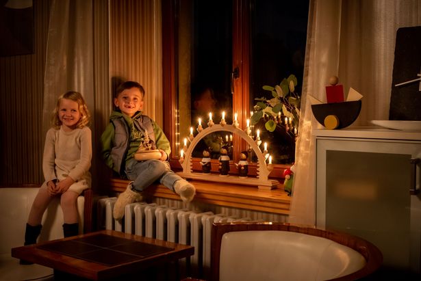 Children sit at the window with a candle arche