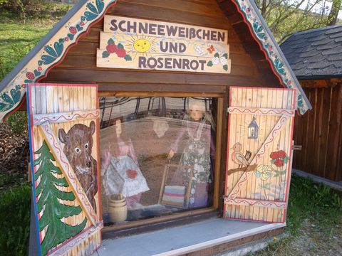 Holzhaus mit Aufschrift Schneeweißchen und Rosenrot auf dem Märchenrundweg in Eibenstock.