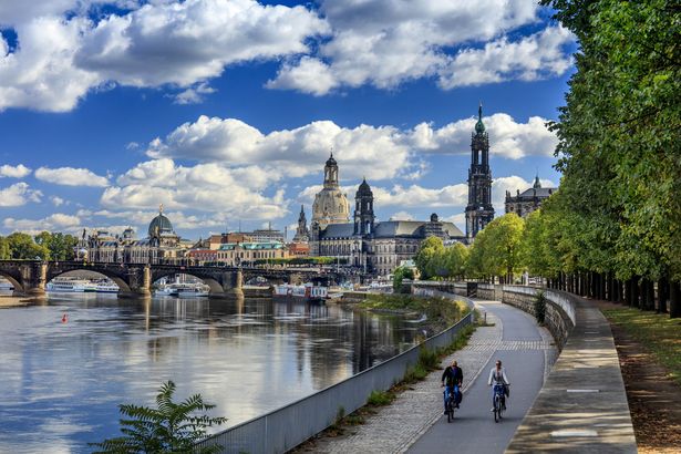 Two cyclists on the Elbe Cycle Route. In the background, you can see the old town of Dresden.