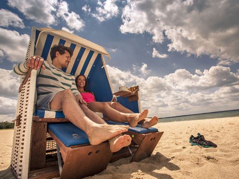 Eine Frau und ein Mann sitzen in einem Strandkorb am Bärwalder See. Sie machen Urlaub im Lausitzer Neuseenland.